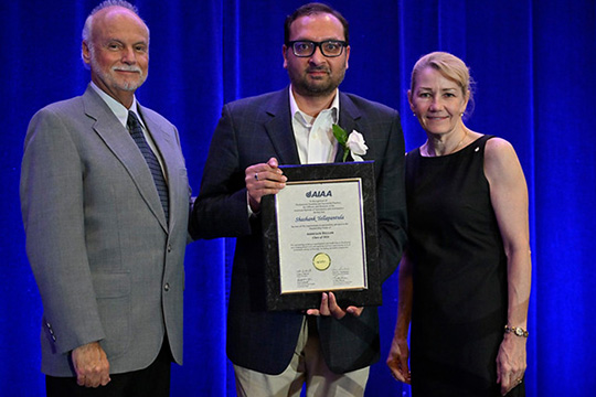 Three people smiling for a picture.