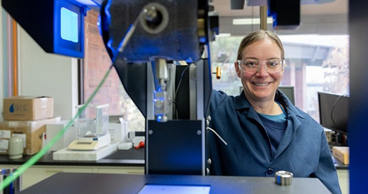 Photo of researcher and scientific equipment in laboratory setting.