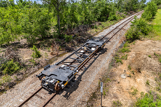 An unloaded automated rail vehicle propels itself down rail tracks in the state of Georgia.